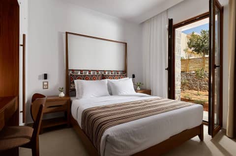 Double bedroom with an embroidered headboard and a window to the garden