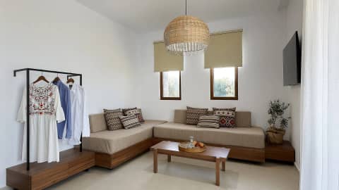 Living corner of a suite with a sofa and an open clothes rail