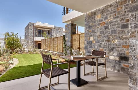 Private garden corner with a table and chairs between the stone walls