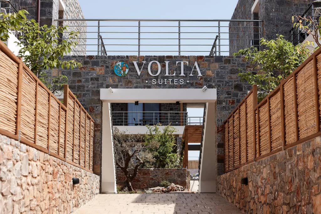 The stone-built entrance of Volta Suites and Villas with the greenery of its garden courtyard