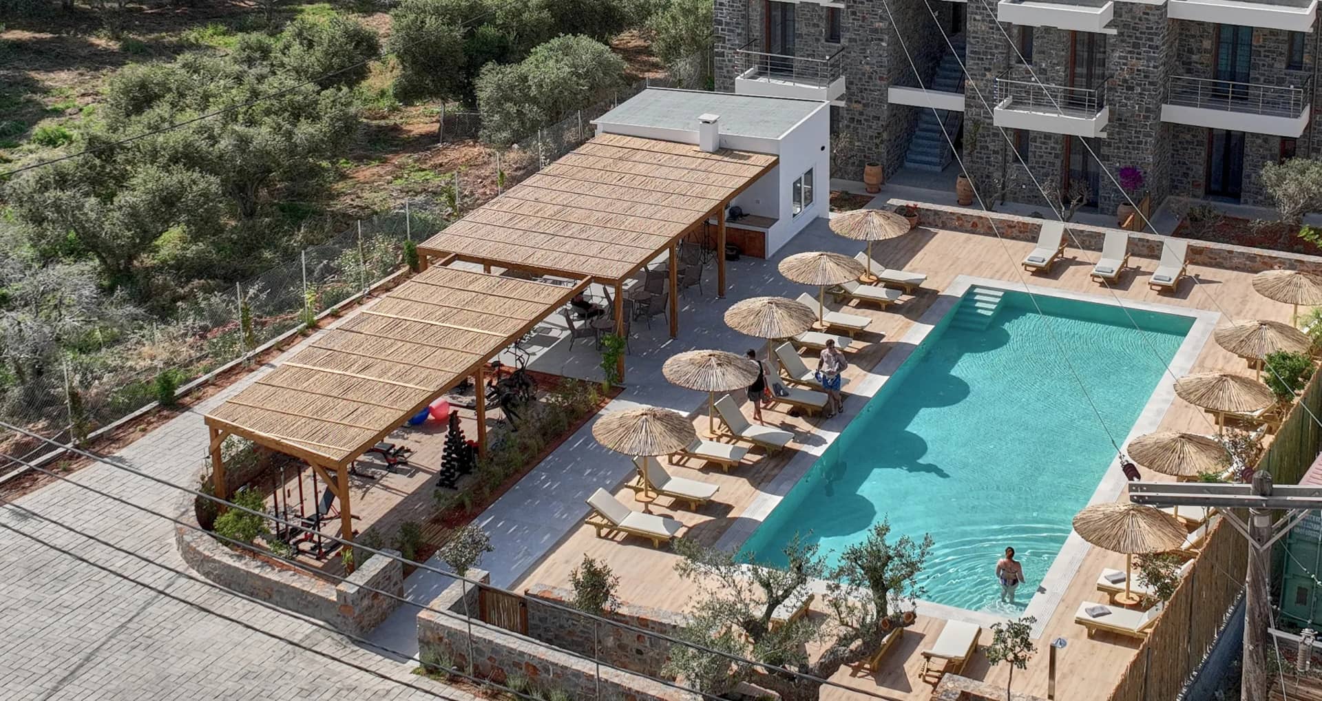 Aerial view of the pool area with the pergola-covered lounge at Volta Suites and Villas