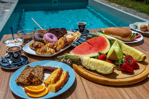 Breakfast with cakes, pastries and fresh fruit board beside a villa private pool at Volta Stay