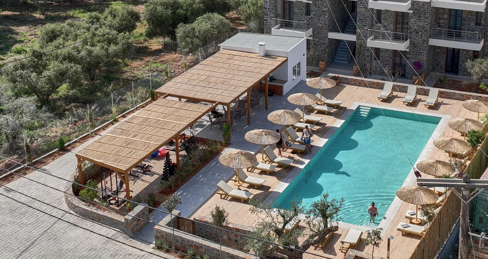 Aerial view of the pool area with the pergola-covered lounge at Volta Suites and Villas