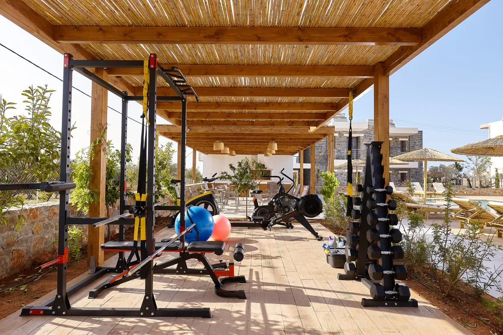 Εξοπλισμός functional training και βάση με αλτήρες στο γυμναστήριο κάτω από την πέργκολα, δίπλα στις πετρόχτιστες σουίτες